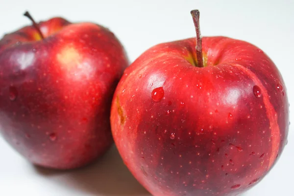 Pommes rouges juteuses fraîches sur une table blanche — Photo