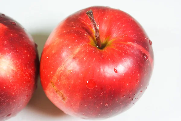 Pommes rouges juteuses fraîches sur une table blanche — Photo