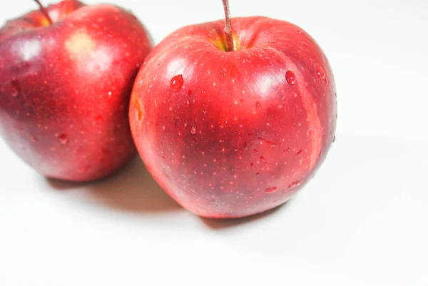 Pommes rouges juteuses fraîches sur une table blanche — Photo