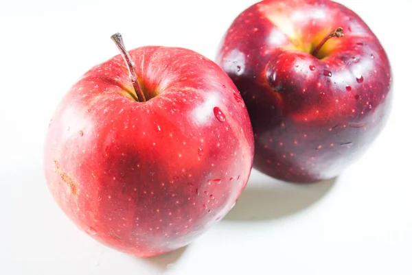 Pommes rouges juteuses fraîches sur une table blanche — Photo