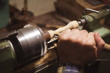 Adam ahşap ayrıntı Torna üzerinde yapar.