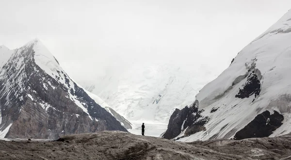 Small man between mountains — Stock Photo, Image