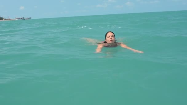 Girl swims in the open sea — Stock Video