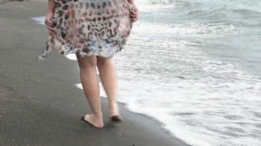 Kumsalda yürüyen kız.