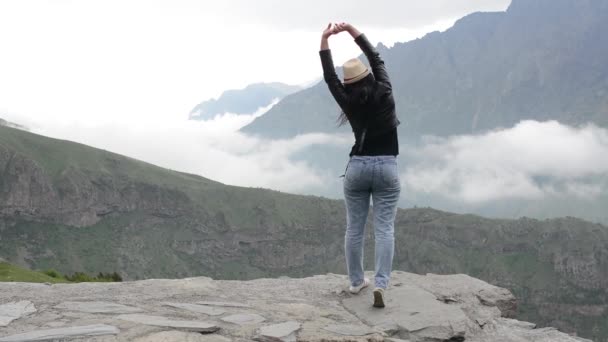 Дівчина захоплюється горами, відпочиває в горах — стокове відео