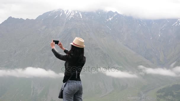 Дівчина захоплюється горами, відпочиває в горах — стокове відео