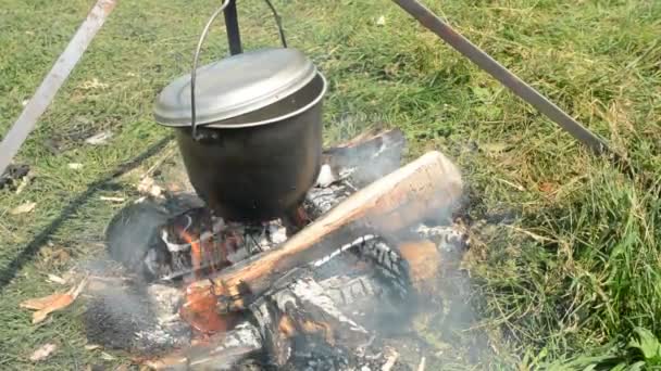 Brazier marching with fire during a halt on the nature. Tourist food in the woods for a picnic. Hiking in the wild. — Stock Video