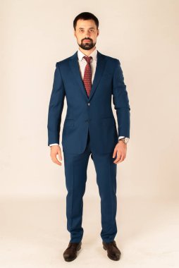 Zarafet ve stil. Smokin ve kırmızı kravat takan yakışıklı genç adam portresi.