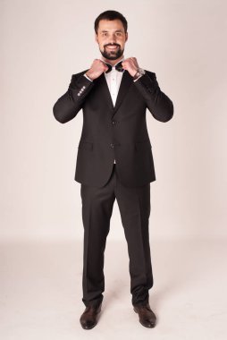 Zarafet ve stil. Smokin ve kırmızı kravat takan yakışıklı genç adam portresi.