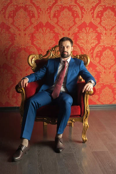 Zarafet ve stil. Smokin ve kırmızı kravat takan yakışıklı genç adam portresi.