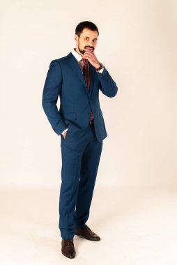 Zarafet ve stil. Smokin ve kırmızı kravat takan yakışıklı genç adam portresi.