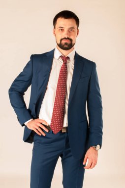 Zarafet ve stil. Smokin ve kırmızı kravat takan yakışıklı genç adam portresi.
