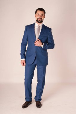 Zarafet ve stil. Smokin ve kırmızı kravat takan yakışıklı genç adam portresi.