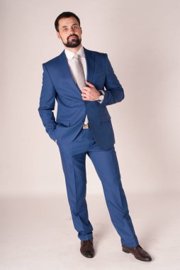 Zarafet ve stil. Smokin ve kırmızı kravat takan yakışıklı genç adam portresi.