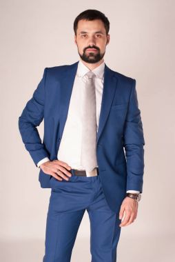 Zarafet ve stil. Smokin ve kırmızı kravat takan yakışıklı genç adam portresi.