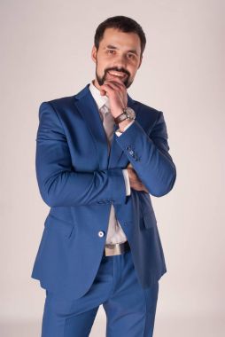 Zarafet ve stil. Smokin ve kırmızı kravat takan yakışıklı genç adam portresi.