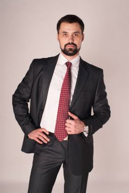 Zarafet ve stil. Smokin ve kırmızı kravat takan yakışıklı genç adam portresi.