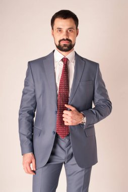 Zarafet ve stil. Smokin ve kırmızı kravat takan yakışıklı genç adam portresi.