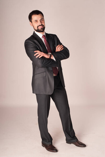 Elegance and style. Portrait of handsome young man wearing tuxedo and red tie.