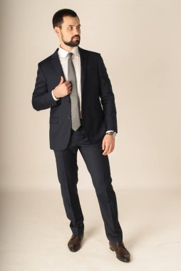 Zarafet ve stil. Smokin ve kırmızı kravat takan yakışıklı genç adam portresi.