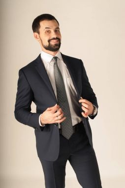 Zarafet ve stil. Smokin ve kırmızı kravat takan yakışıklı genç adam portresi.