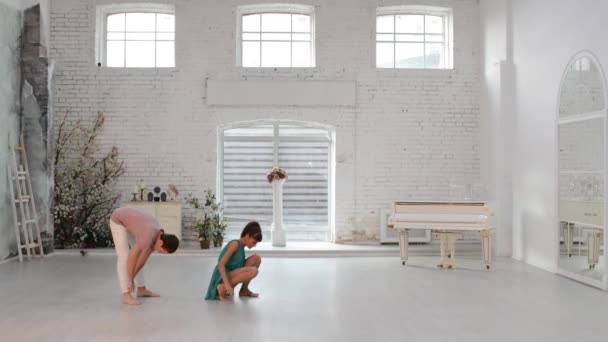 Девушка с парнем танцует гимнастический танец в танцевальном зале — стоковое видео