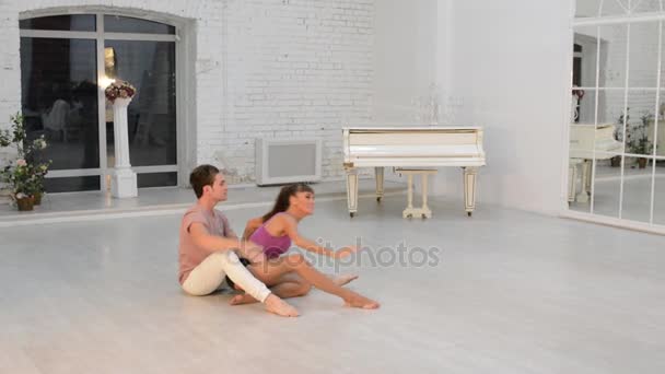 Девушка с парнем танцует гимнастический танец в танцевальном зале — стоковое видео