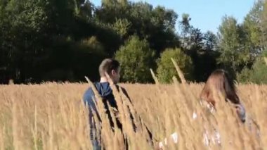 Bir alanda yürüyüş ve gün batımında elele çift. Ağır çekimde filme.