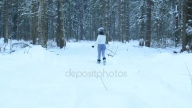 Oynak kız kamera, beyaz sıçramalarına sinek çevrede için düz kartopu atmak. Barışçı çevresinde kar ve ormanda yürür. Kar yavaş yavaş düşmek.
