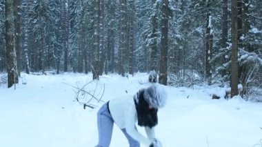 Oynak kız kamera, beyaz sıçramalarına sinek çevrede için düz kartopu atmak. Barışçı çevresinde kar ve ormanda yürür. Kar yavaş yavaş düşmek.