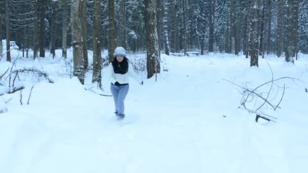 滑稽顽皮的女孩抛出雪球直接到相机, 白色飞溅周围飞。在雪地里闲逛, 在树林里漫步。雪花缓缓落下. — 图库视频影像