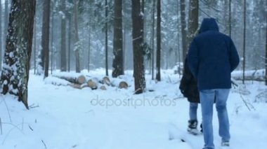 Arkadaşlar bir orman kış yolda git. Ağır kar.