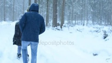 Arkadaşlar bir orman kış yolda git. Ağır kar.