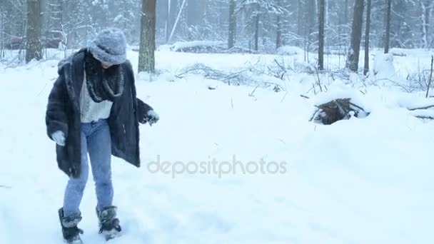 Chica divertida juguetona tonteando en la nieve y pasea por el bosque. Caída de nieve . — Vídeos de Stock