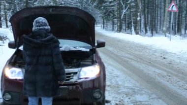 Ormandaki bir kış yolda araba sorunu olan kadın. Evet.