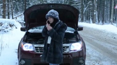 Ormandaki bir kış yolda araba sorunu olan kadın. Evet.