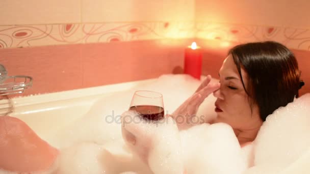 美丽的女孩与一杯红酒泡泡浴 大白浴和他脸上的喜悦 松弛概念 — 图库视频影像