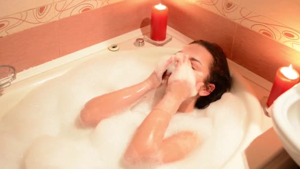 一个年轻的女孩洗澡的泡沫 一个大的白色浴缸 — 图库视频影像