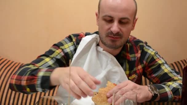 Junger Mann Isst Fast Food Hamburger Und Trinkt Bier — Stockvideo