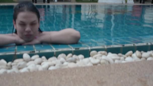 ブルネットの少女がプールで泳ぐ — ストック動画