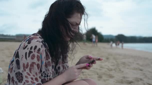 Brünettes Mädchen Sitzt Einem Strand Mit Einem Telefon — Stockvideo