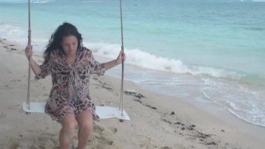 Esmer kız plaj salıncakta sallanan