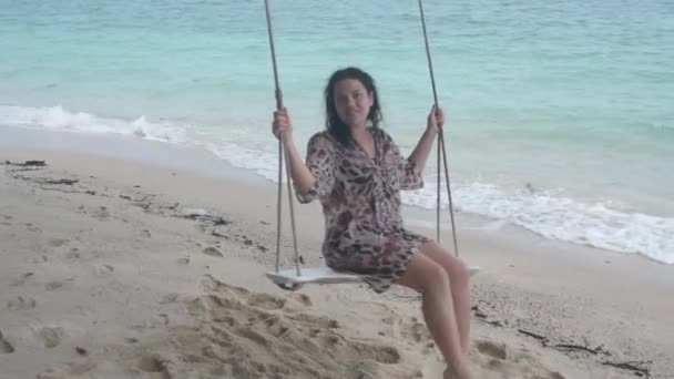 在沙滩秋千上摇摆的黑发女孩 — 图库视频影像