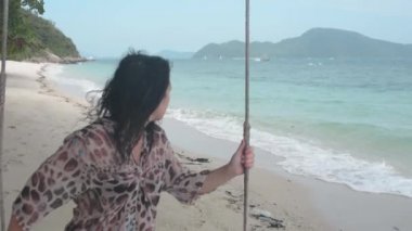 Esmer kız plaj salıncakta sallanan