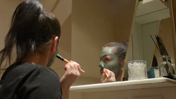 Menina Provoca Máscara Argila Rosto — Vídeo de Stock