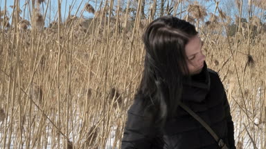 Bir kış parkta şık genç güzel kadın portresi kadar karlı arka plan üzerinde kapatın. Kış park kamera için arıyorum. Kar yağıyor. açık havada. güzel genç kadın bir kışın yürüyor