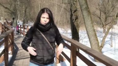 Bir kış parkta şık genç güzel kadın portresi kadar karlı arka plan üzerinde kapatın. Kış park kamera için arıyorum. Kar yağıyor. açık havada. güzel genç kadın bir kışın yürüyor