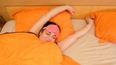 Closeup 4k video uyuyan genç kadın gözleri bağlı maske takıyor. Uyanır ve bandaj kaldırır. Farkında o kaçırdı