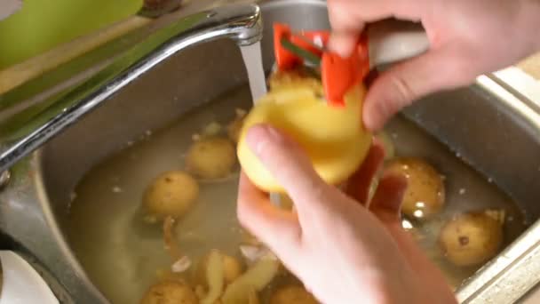 Mannelijke Handen Peeling Rauwe Aardappelen Met Een Mes Spoelbak Met — Stockvideo