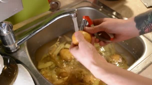 Mãos Masculinas Descascando Batatas Cruas Com Uma Faca Pia Com — Vídeo de Stock